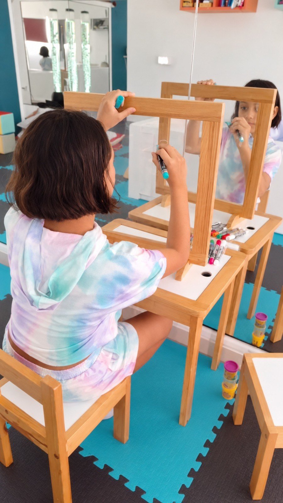 Niña realizando ejercicio gráfico frente al espejo para atención, coordinación visomotora y expresión gráfica