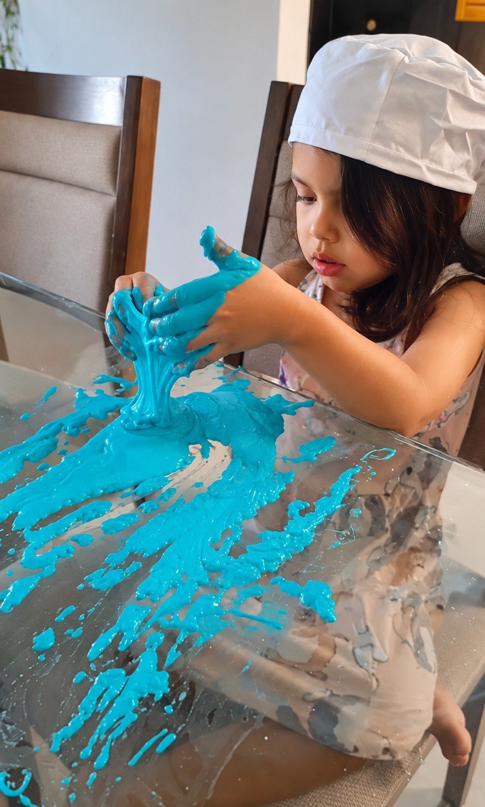 Niña manipulando material de textura viscosa para exploración táctil, motricidad fina y autorregulación